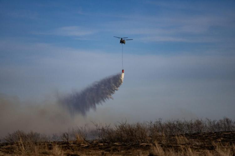A Chinook helicopter dumps water on the Smokehouse Creek Fire in Hemphill County after high winds caused a flare-up. (Texas A&M AgriLife photo by Sam Craft)