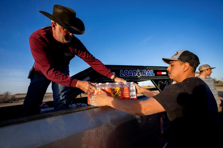 A Texas A&M AgriLife Extension Service Disaster Assessment and Recovery agent unloads donated water at an animal supply point set up in Pampa to help with disaster relief for the Smokehouse Creek fire. (Texas A&M AgriLife photo by Sam Craft)