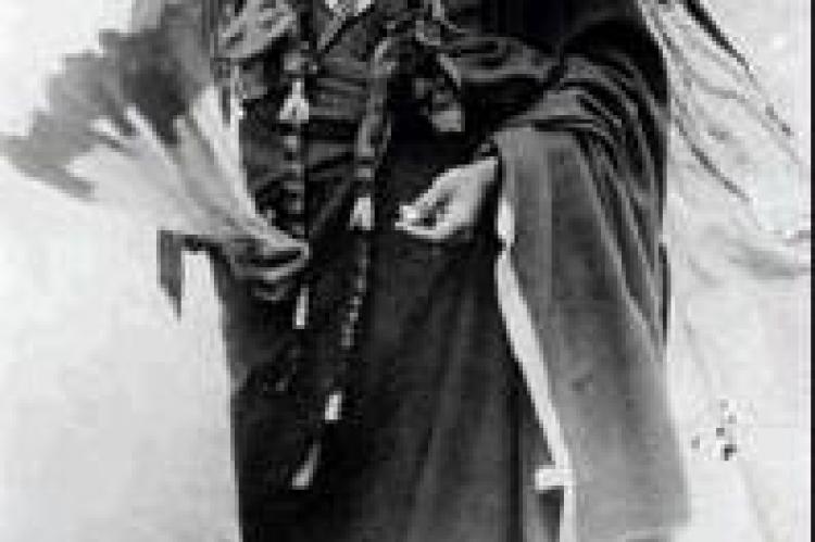 Quanah Parker, c. 1885, wearing Peyote robe, carrying Eagle feather fan, standing in front of teepee. Photo by Hutchins &amp; Lanney, Smithsonian Institution