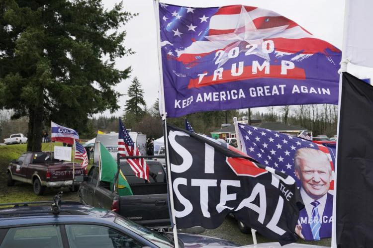 Flags supporting President Donald Trump and one that reads “Stop the Steal” are displayed during a protest rally, Jan. 4, 2021, at the Farm Boy Drive-In restaurant near Olympia, Wash. (AP Photo/Ted S. Warren)
