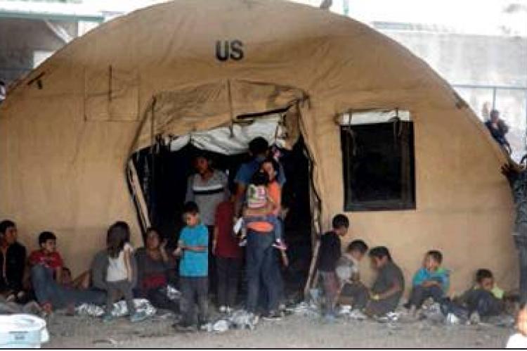 Families outside a tent at a temporary migrant holding area set up by Customs and Border Protection under the Paso del Norte International Port of Entry between Juarez and El Paso, on March 27, 2019. IVAN PIERRE AGUIRRE | THE TEXAS TRIBUNe