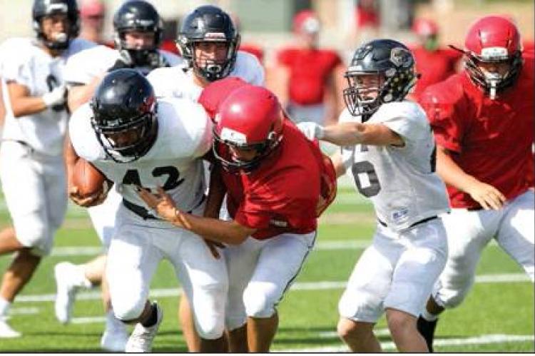 Israel Guerrero (42) is flanked by Landon Smith (6) while fighting off a Bulldog defender during last Saturday’s scrimmage at Borger. SCRIMMAGE PHOTOS BY MICHAEL KERRIGAN
