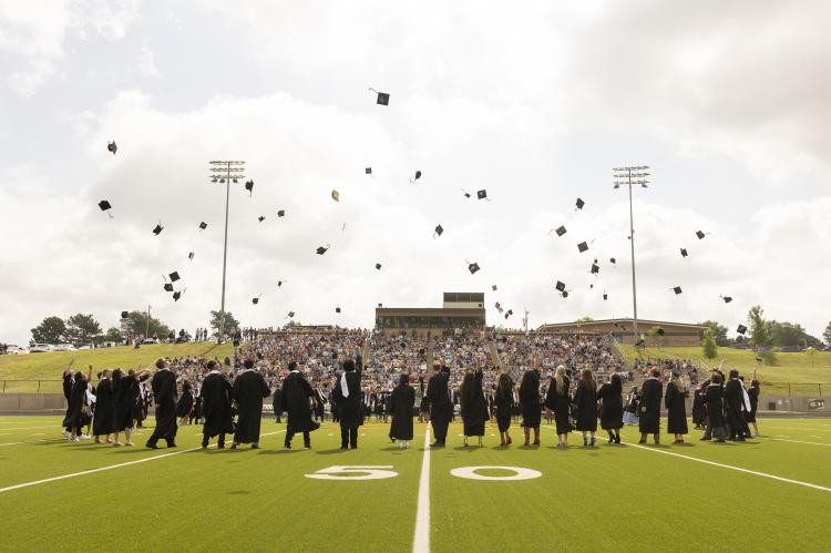 New CHS graduates toss their caps in the air following Saturday ceremony