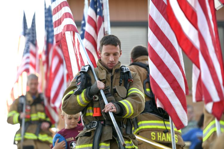 Bryan Bartlett and his fellow volunteer firefighters climb the steps of Wildcat Stadium in 2021 9/11 tribute 