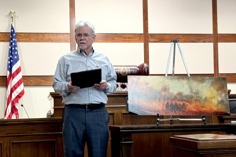 Artist Richard Sukup reads text he wrote for plaque accompanying his painting, "Only The Courageous"