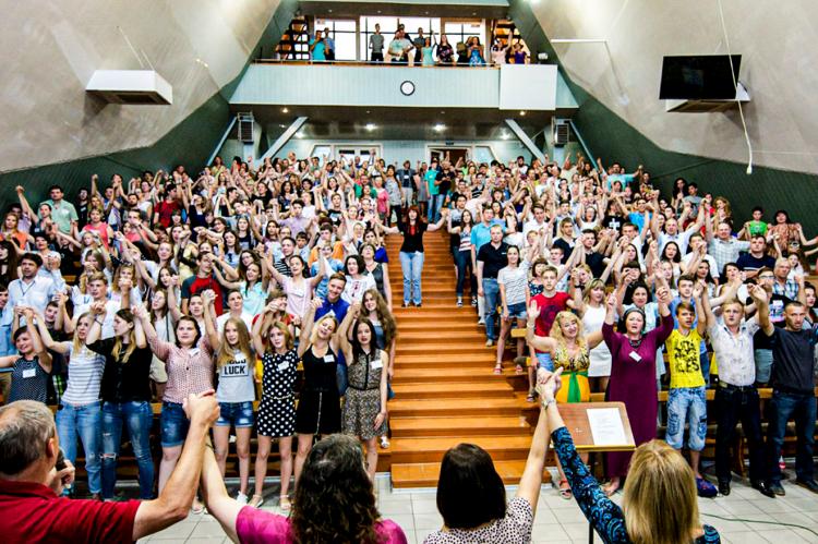 Betty Bynum is in photo, facing a church full of students at the conclusion of their classes in Mariupol in 2018.