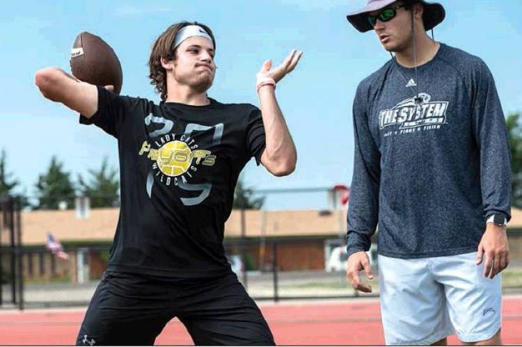 Grant McCook passing under close supervision from the staff during throwing drills. HALE HUGHES PHOTO