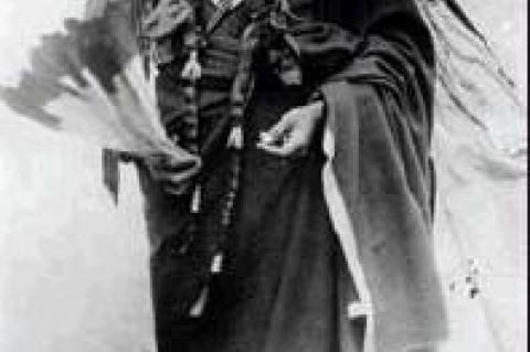 Quanah Parker, c. 1885, wearing Peyote robe, carrying Eagle feather fan, standing in front of teepee. Photo by Hutchins &amp; Lanney, Smithsonian Institution