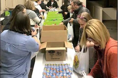 Volunteers man the assembly line at the local Snack Pak 4 Kids sacking day