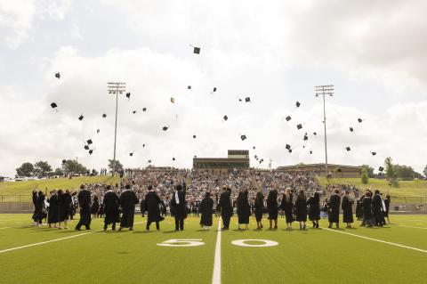 New CHS graduates toss their caps in the air following Saturday ceremony