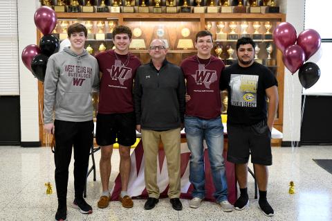Josh Culwell, Reagan Cochran, Ethan Jackson, and Edgar Salazar with Wildcat Head Coach Chris Koetting on Signing Day at CHS