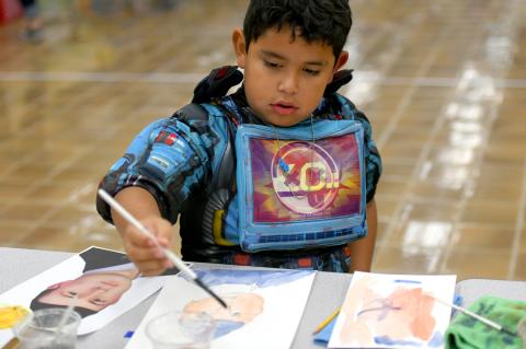 This BES second-grader studiously compares his painting of Hayze Hufstedler to the photograph, and carefully adjusts the skin tone