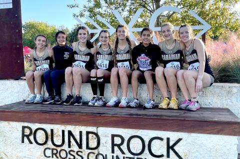 Lady Cat cross-country team members Kimora Morales, Yessica Martinez, Ella Walser, Payton Lee, Brooklyn Beedy, Elizabeth Guerrero, Arionna Black, and Konnar McClendon, sitting on the Wall of Champions.