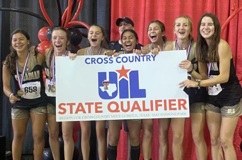 The Lady Cat cross-country team celebrates their historic victory with Coach Aaron Marks