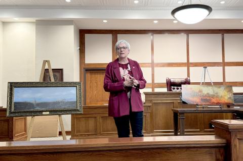 Hemphill County Judge Lisa Johnson with paintings commemorating 2024 Smokehouse Creek Fire