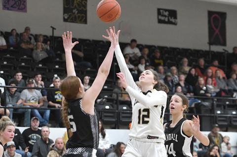 Senior Briley Merket (12) takes a jumper between two defenders