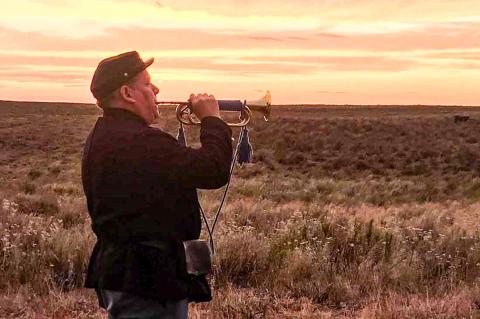 Chris Larson playing “Taps” at last year’s anniversary memorial. Larson is secretary of the Frontier Regiment of the High Plains, a group of scholars and re-enactors of the Red River Wars and other High Plain history.