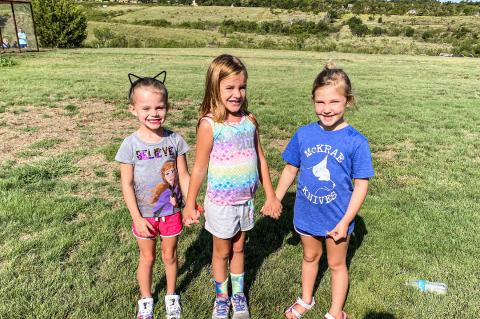 Kynslea Smith (left) Kota Shrader (center) and Emery Timmons (right) play together in the sunshine.