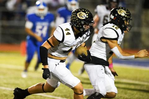 Wyatt Davis (44) tucks in his pick-six while Eric Avila (12) blocks