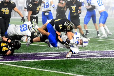 Defensive lineman D'Wayne Moran (64) takes down Gunter's Ethan Sloan