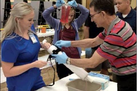 RN Mayci Savard and CHS math teacher Steve Hutsell applying a tourniquet