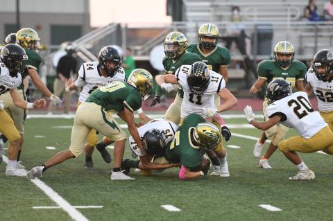 Wildcats Alan Jara (No. 75), Everett Hadaway (No. 11) stop Hornet ball carrier Cade Seaman (No. 5), as teammates Luke Flowers (No. 25), Matt McLanahan (No. 24), Isay Ramires (No. 20) and Jake Krehbiel (No. 22) swarm.