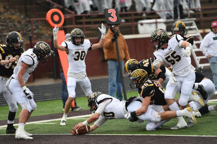 Wildcat Quarterback Grant McCook (10) dives for the goalline—one of 18 for the season—as teammate Bill Koetting (30) signals the touchdown and teammates Hayes Hufstedler (21) and Rhett Pennington (55) look on. 