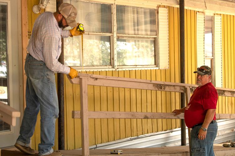 Volunteers build a wheelchair ramp in front of someone's home