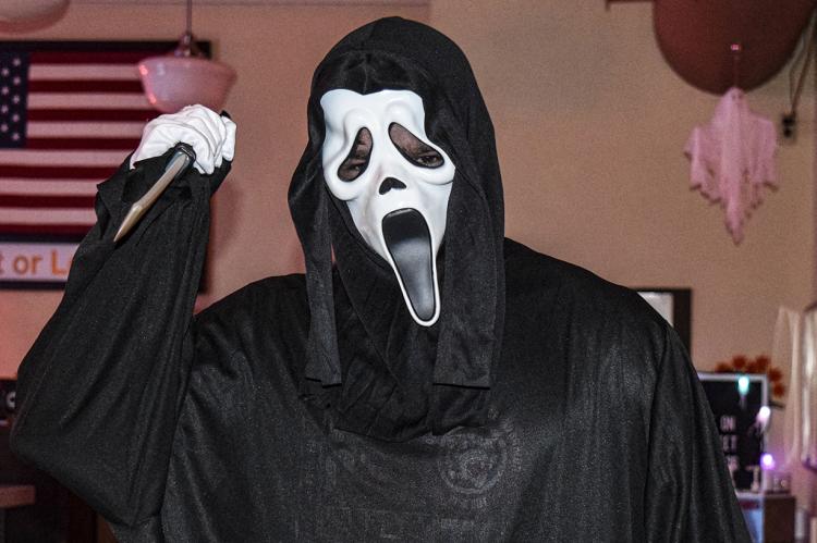  Palace Theatre employee Gage Gerhardt as Ghostface from the movie “Scream” greats moviegoers on Saturday