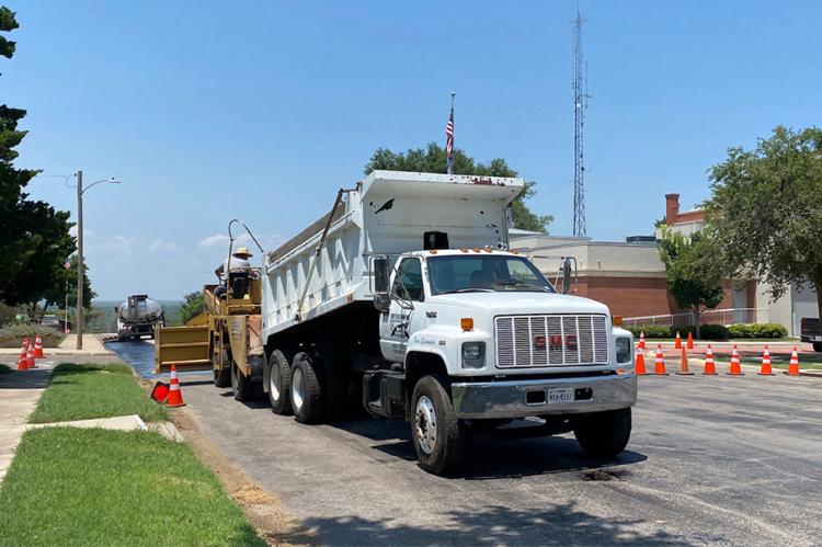 Bryer's Paving began the city sealcoating project Tuesday on Purcell Street with help from city hands who filled holes to ensure an even surface