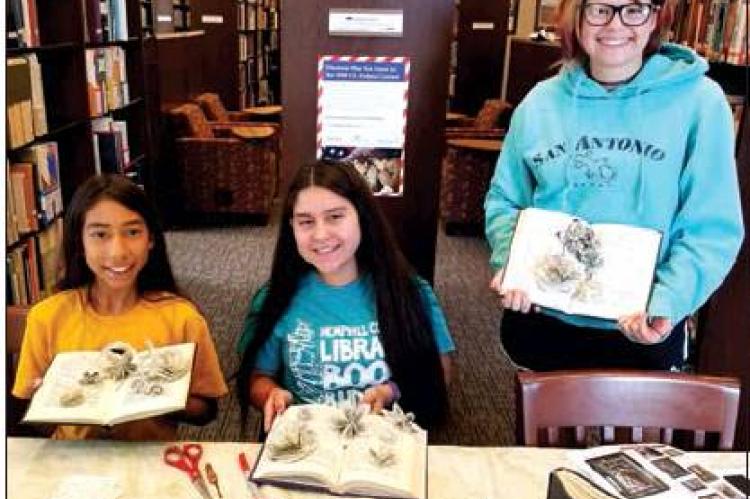 Hemphill County Librarian April Dillon taught a trio of teenagers how to make flowers out of old books during a recent Summer Reading program. Showing their creations are (l-r) Perla Vigil, Emely Perez, and Ashlyn Phillips.