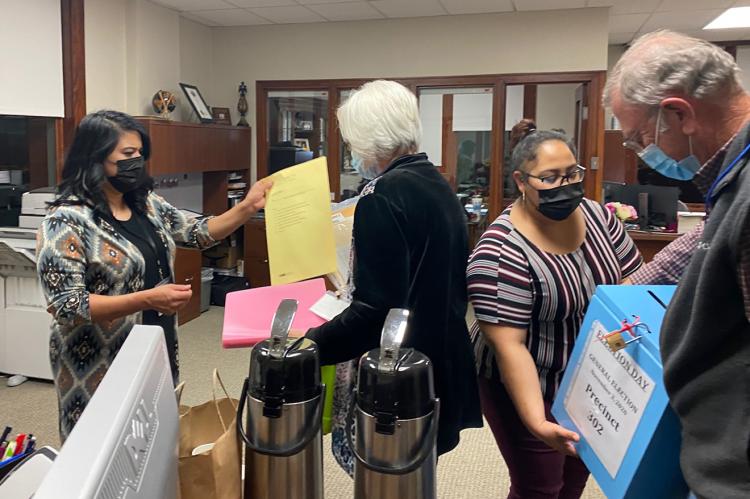 Clerk’s office employees Sylvia Guerrero and Rosa Gandara collect the ballots and reports from Keith and Vonda Robbins, who worked the Precinct 302 polling place. 
