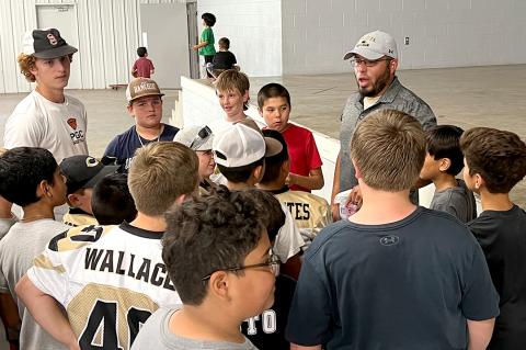Camren Cavalier and Reyes coach up a group of Junior Wildcats, and below, a trio of young athletes compete with varying degrees of intensity in the cornhole tournament.