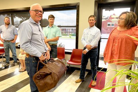 Retiring HCUWCD Chairman Jim Haley was honored in a Thursday reception prior to his last official board meeting, and was presented with a beautiful leather bag by District General Manager Janet Guthrie, who sent him packing. In the background are the new generation of directors who have stepped up to lead the district, including (from left) Spencer Hanes, Tom Isaacs, and Craig Cowden.