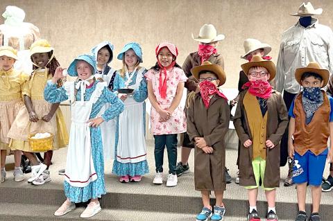 Canadian second-grade students try out pioneer clothing.