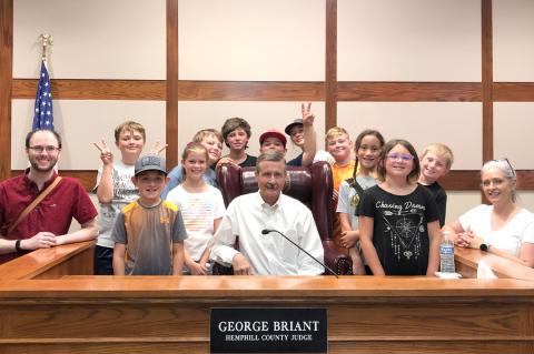 Joining the camp on the Main Street tour were: (l-r) intern Zach Reis, Kyle Wright, Lucas LeFever, Ella Moss, Eric Wilson, Trevor Powell, Easton Schafer, Sterling Thomas, Morgan Bradford, Esmeriah Shields, Natilyn Bradford, Corben Whittle and Wendy Wright, with Judge George Briant (center).
